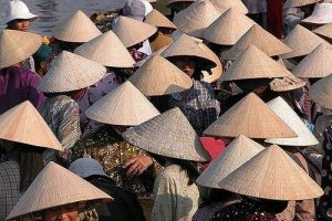 Vietnamitas usando chapéus cónicos tradicionais, conhecidos como nón lá