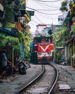Comboio a passar junto a casas e cafés na estreita Train Street, em Hanói, uma das assustadoras curiosidades sobre o Vietname