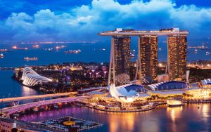 Bar rooftop com vista noturna para o skyline de Singapura
